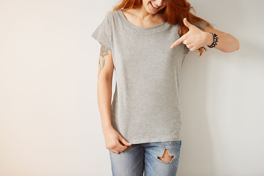 Women pointing her fingers to her shirt with her perfectly fitted bra.